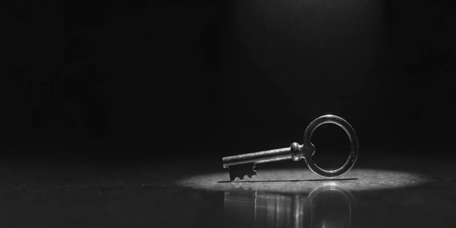 Close-up van een ouderwetse sleutel in een slot, fel spotlicht tegen een donkere achtergrond, symbool voor digitale toegangsbeveiliging