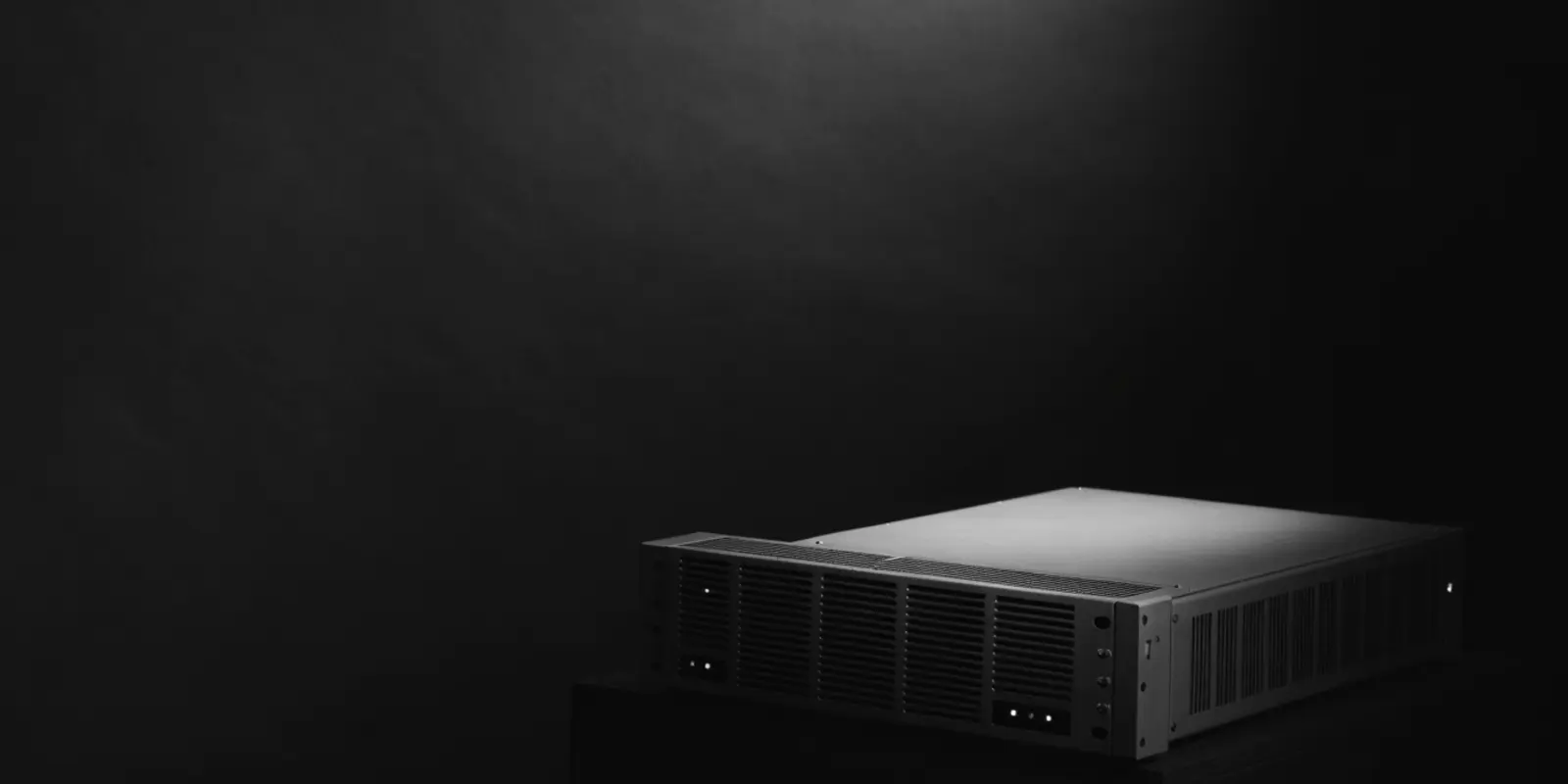 Zwart-wit stilleven van een serverkast in spotlicht tegen een donkere achtergrond