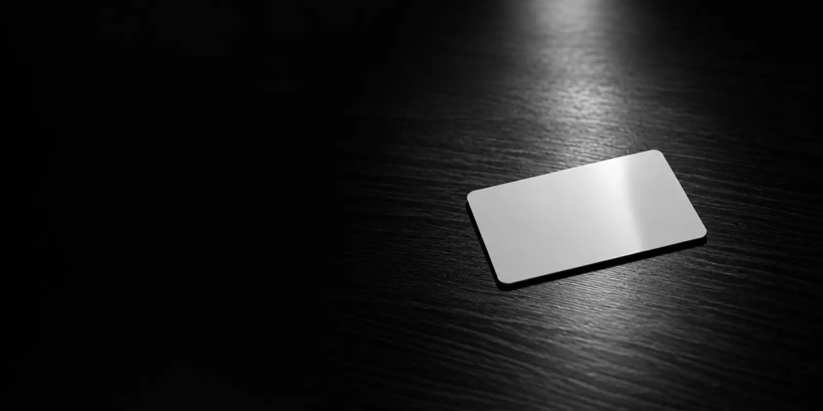 Een blanco toegangspas ligt op een donker bureau, verlicht door een spotlight, als symbool voor toegang die niet is ingetrokken.