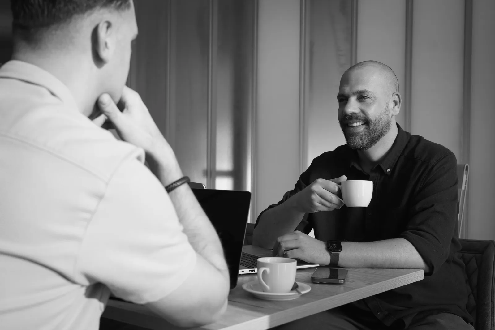 Motics in gesprek met een klant, ontspannen bij een kop koffie