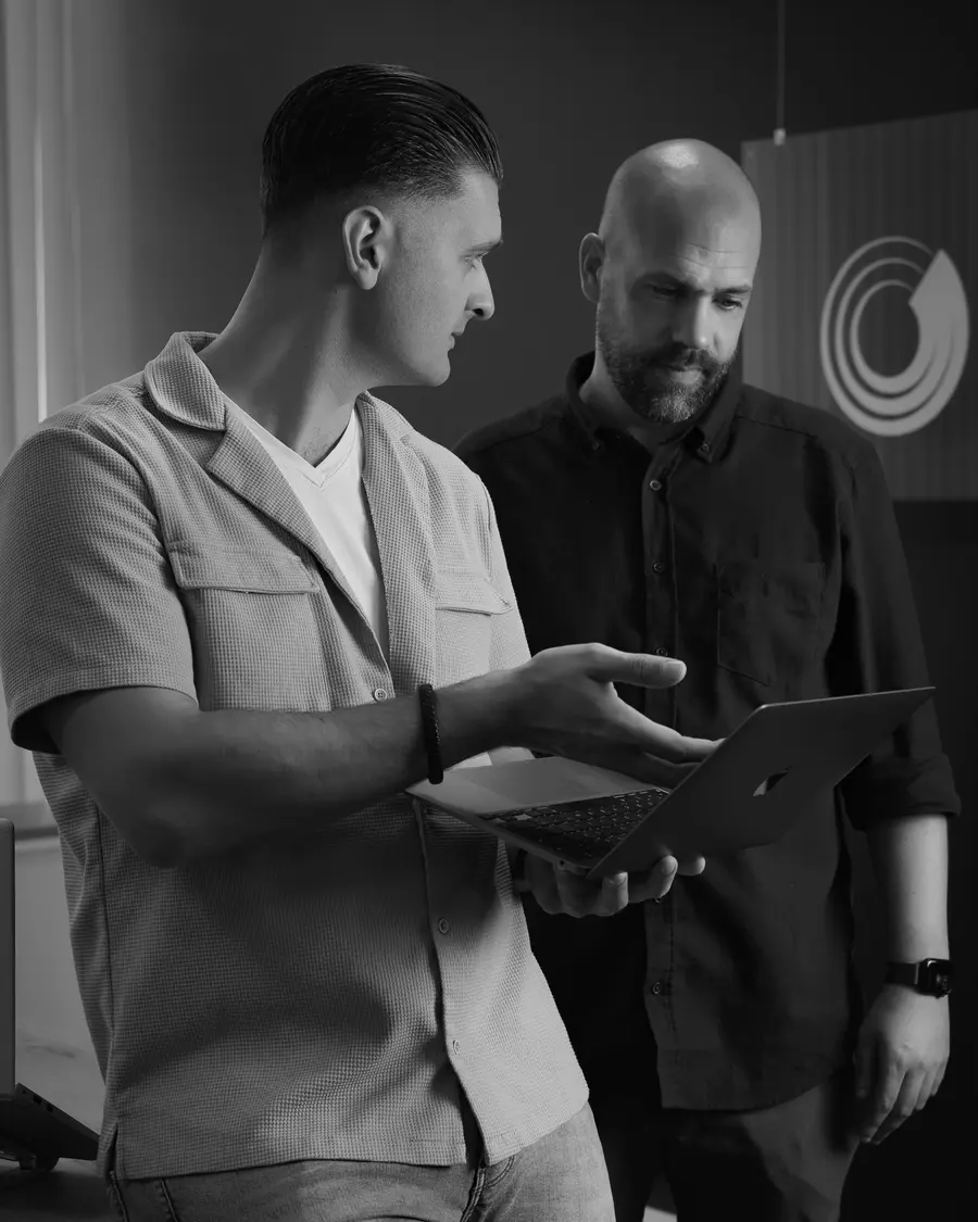 Twee collega’s van Motics overleggen samen bij een laptop